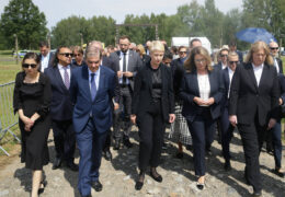 Eine Gruppe Menschen läuft durch das Tor des ehemaligen Lagerabrschnitts B II e in Auschwitz-Birkenau