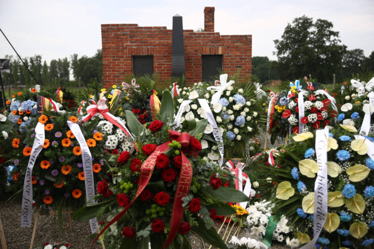 Gedenkkränze stehen vor einem Backsteindenkmal
